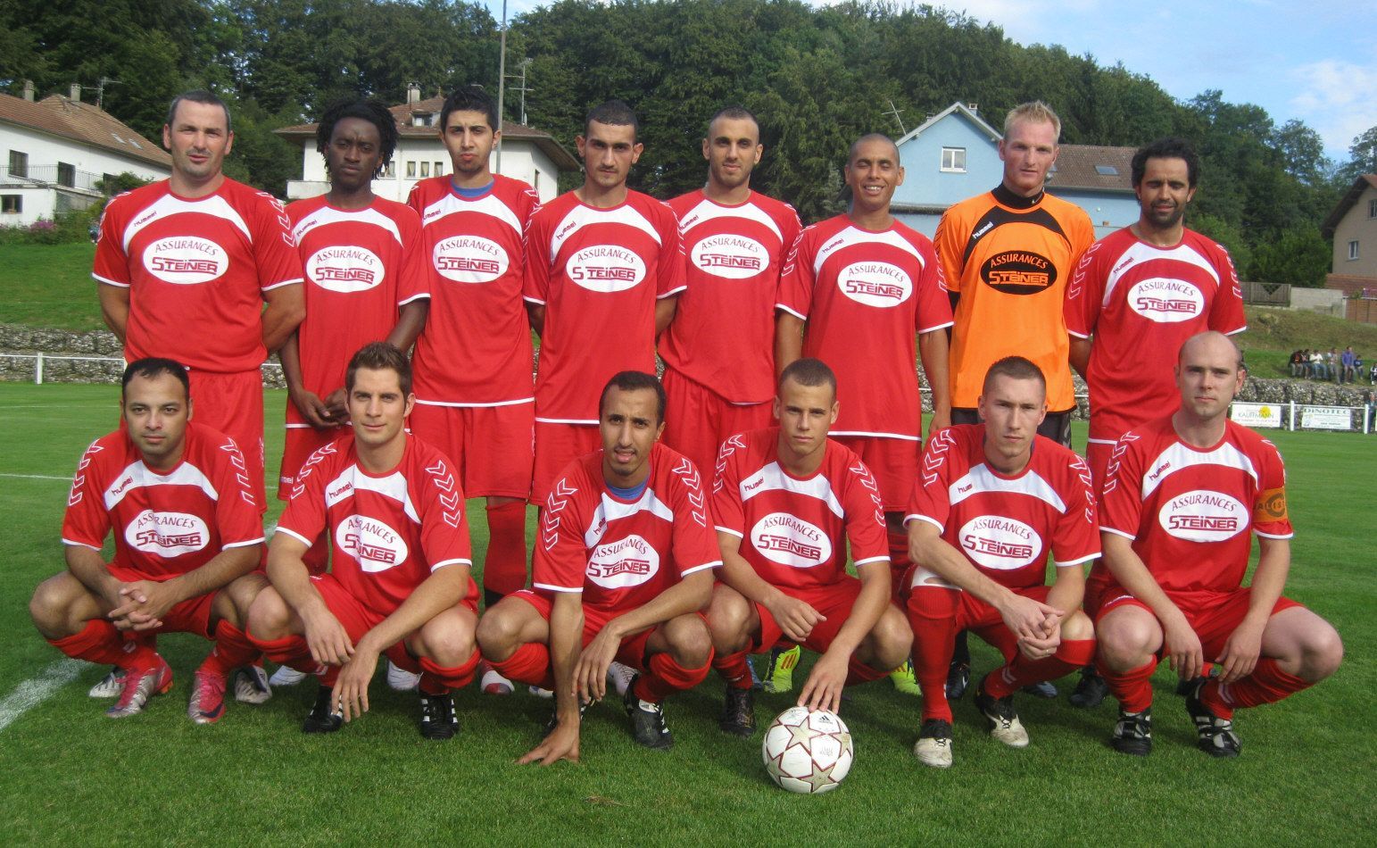 Un groupe de joueurs de football posant pour une photo sur un terrain