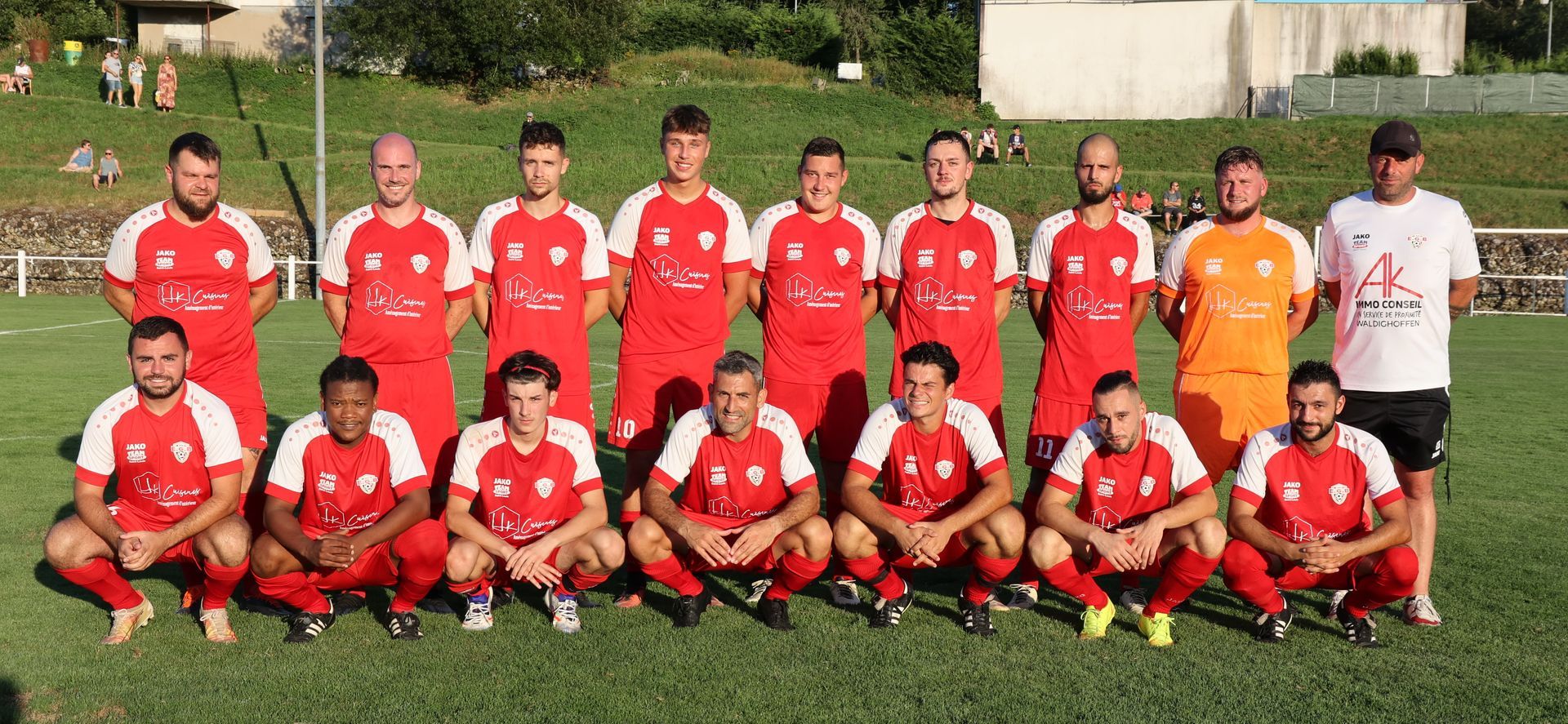 Une équipe de football pose pour une photo sur un terrain.