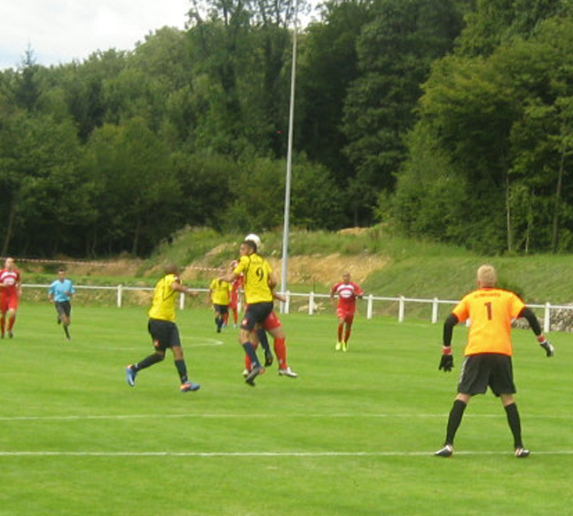 Un groupe de joueurs de football jouent à un jeu sur un terrain