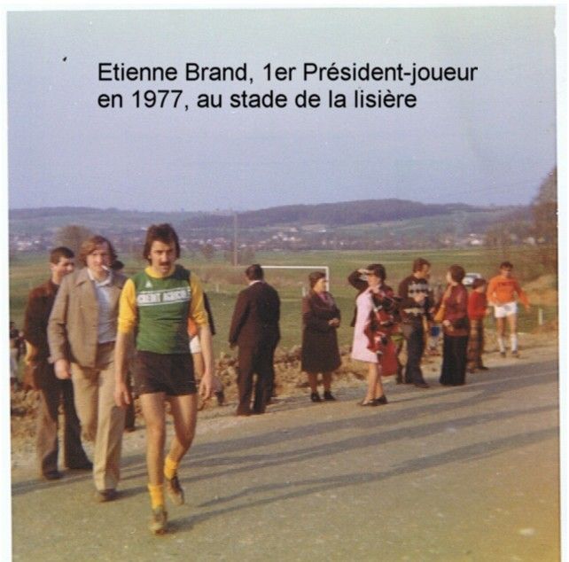 Un homme portant une chemise verte et jaune marche dans la rue