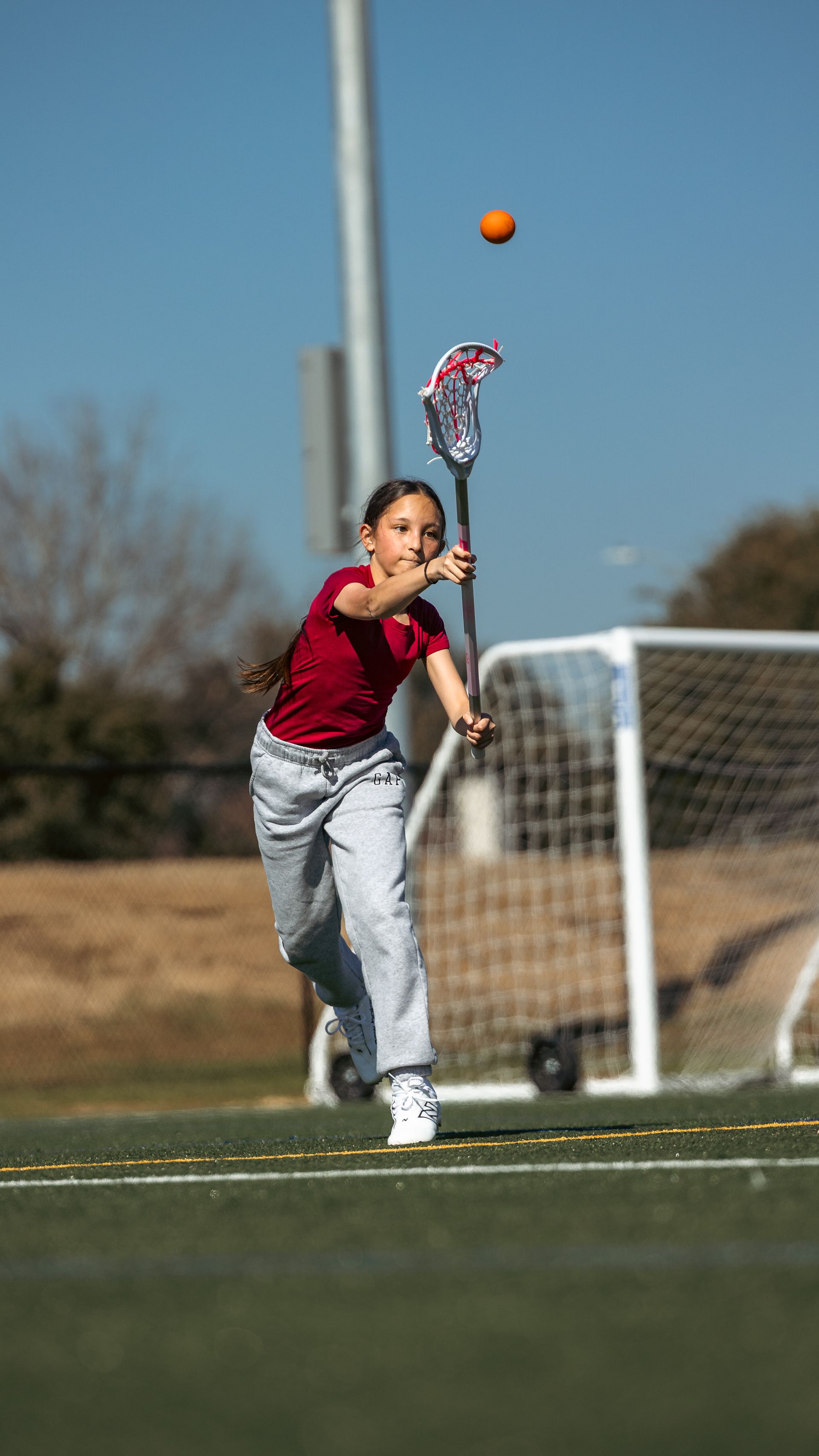 Albion Lacrosse Club youth player throwing the ball