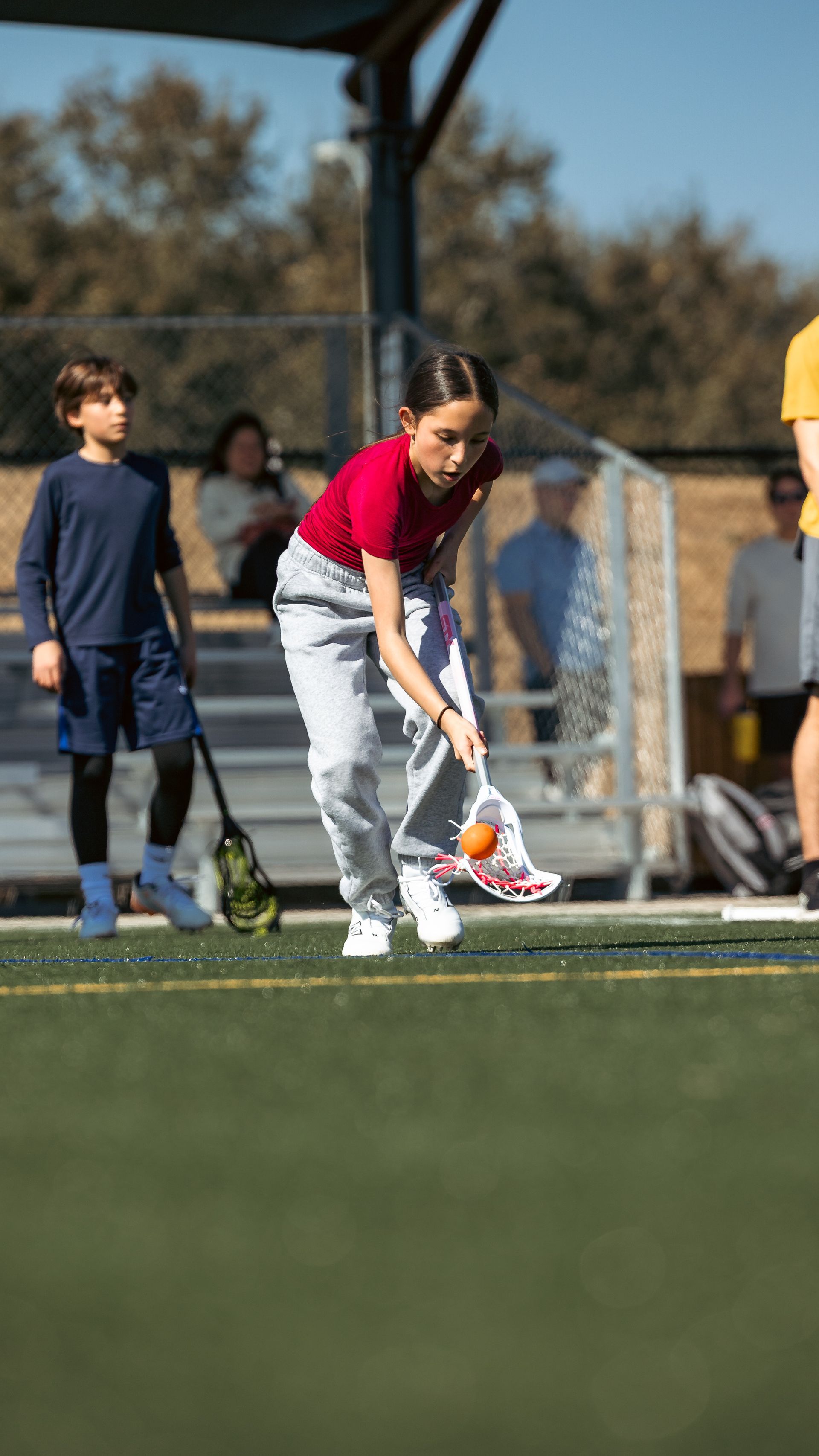 Albion Lacrosse Club youth player with the ball and a stick