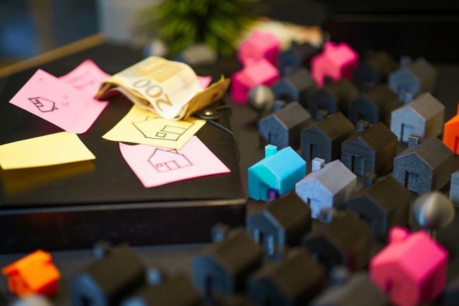 Sticky notes and miniature colorful figures on a black surface, with some notes stacked nearby