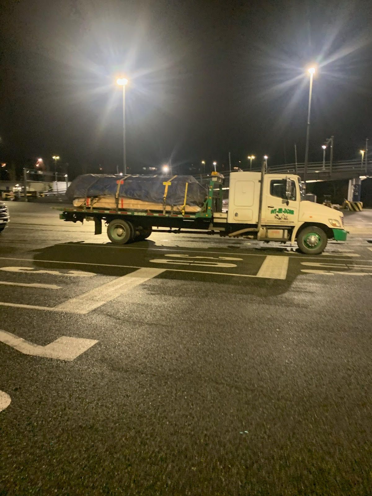 Git-Er-Done towing truck loaded with lumber late at night