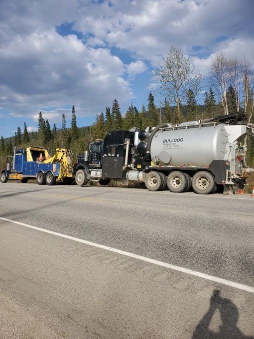 Green Git-Er-Done Towing truck hauling large work vehicle