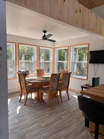 Une salle à manger avec une table et des chaises et un ventilateur de plafond.