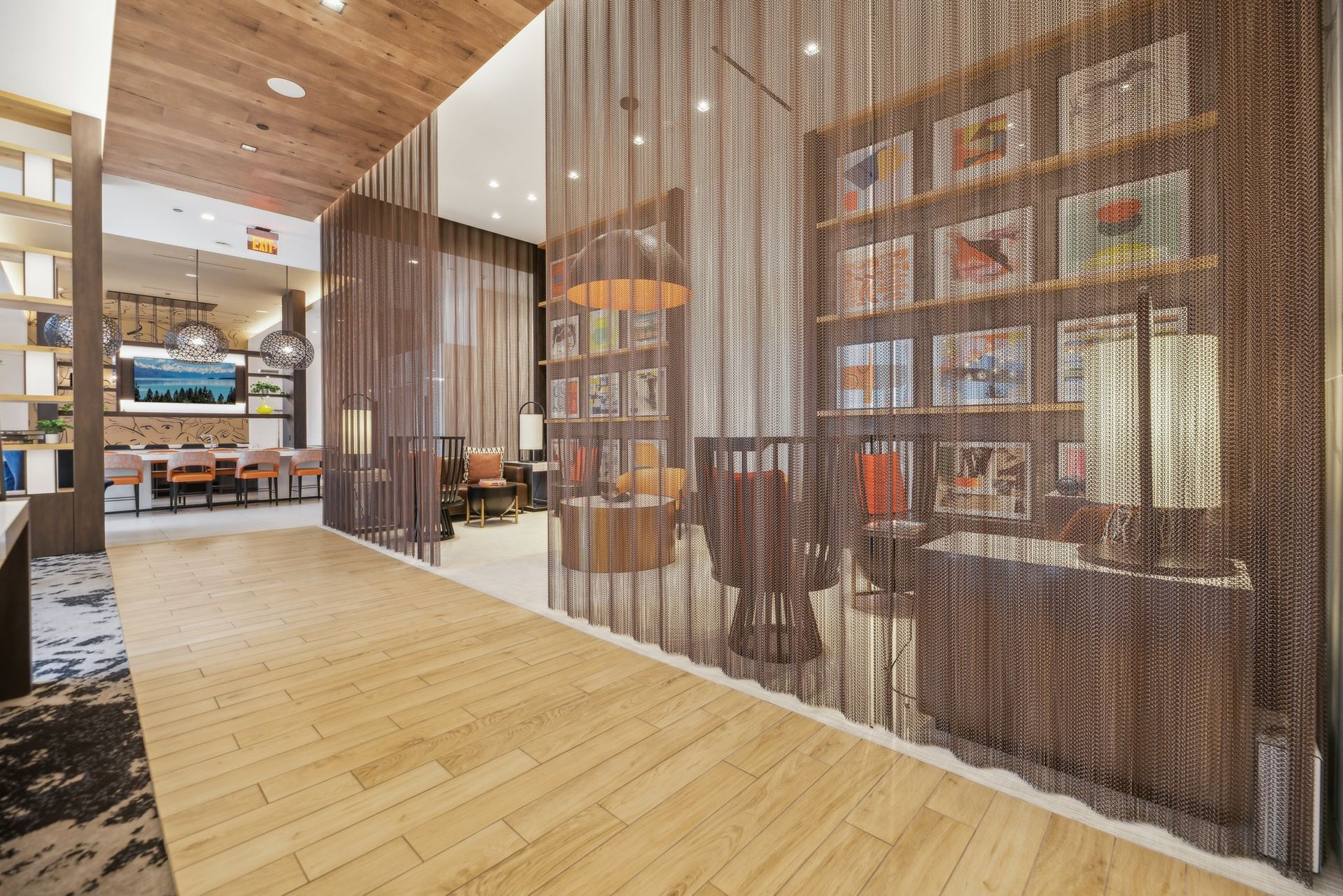 An artist's impression of a hotel lobby with a wooden floor and a bookshelf at Solaire 8200 Dixon offers apartments in Silver Spring, MD.