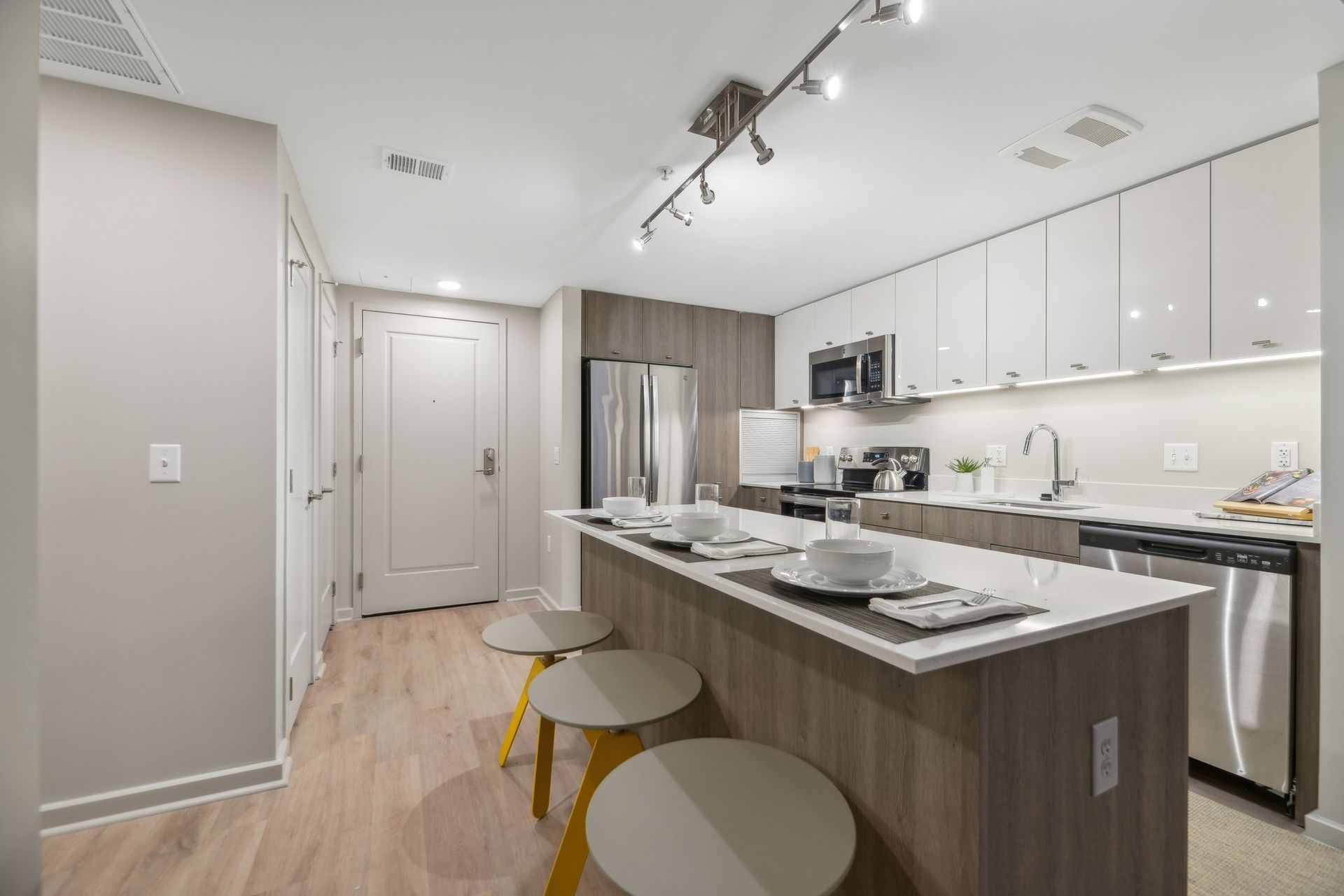 A kitchen with a large island and stools in it at Solaire 8200 Dixon offers apartments in Silver Spring, MD.