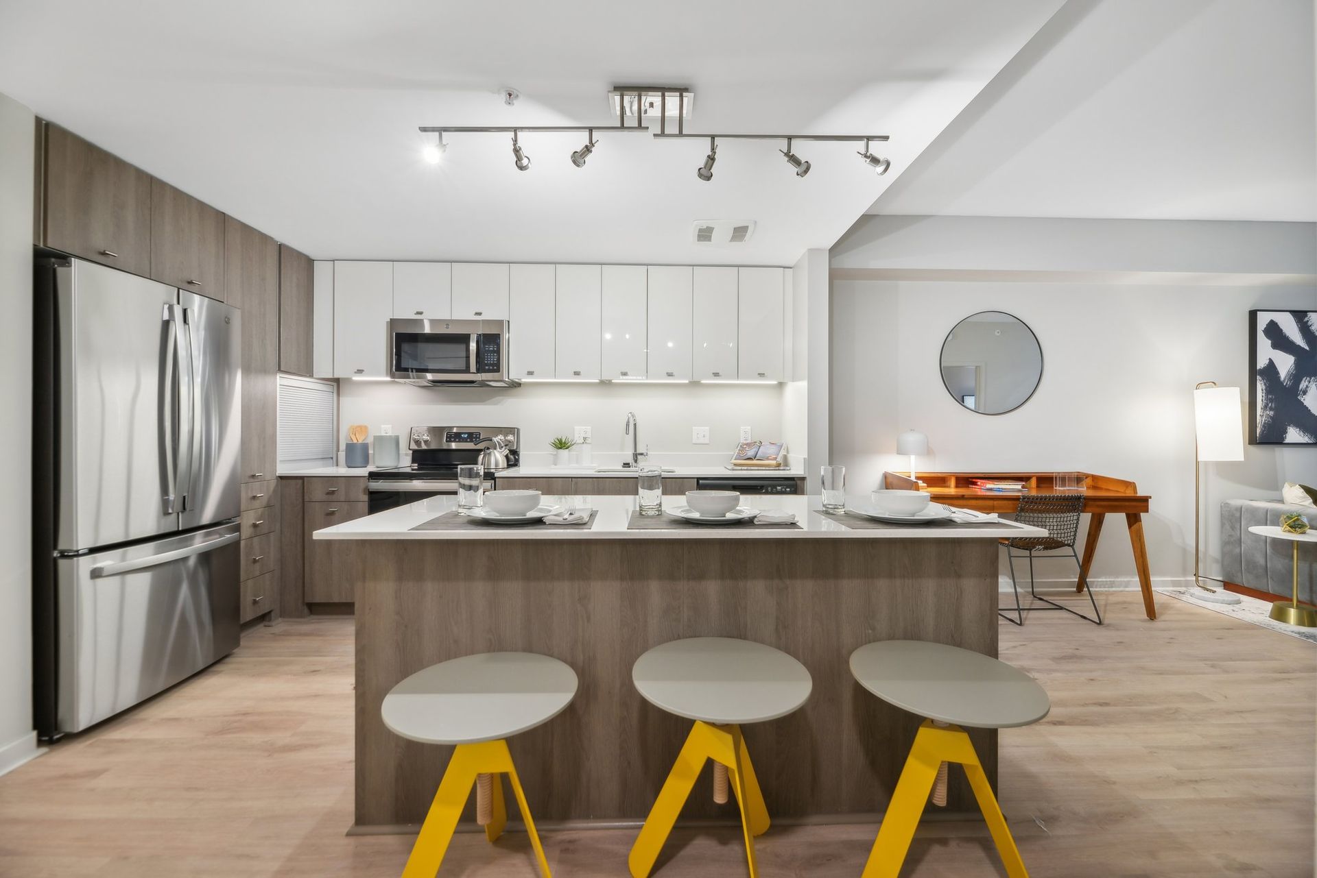A kitchen with a large island and yellow stools at Solaire 8200 Dixon offers apartments in Silver Spring, MD.