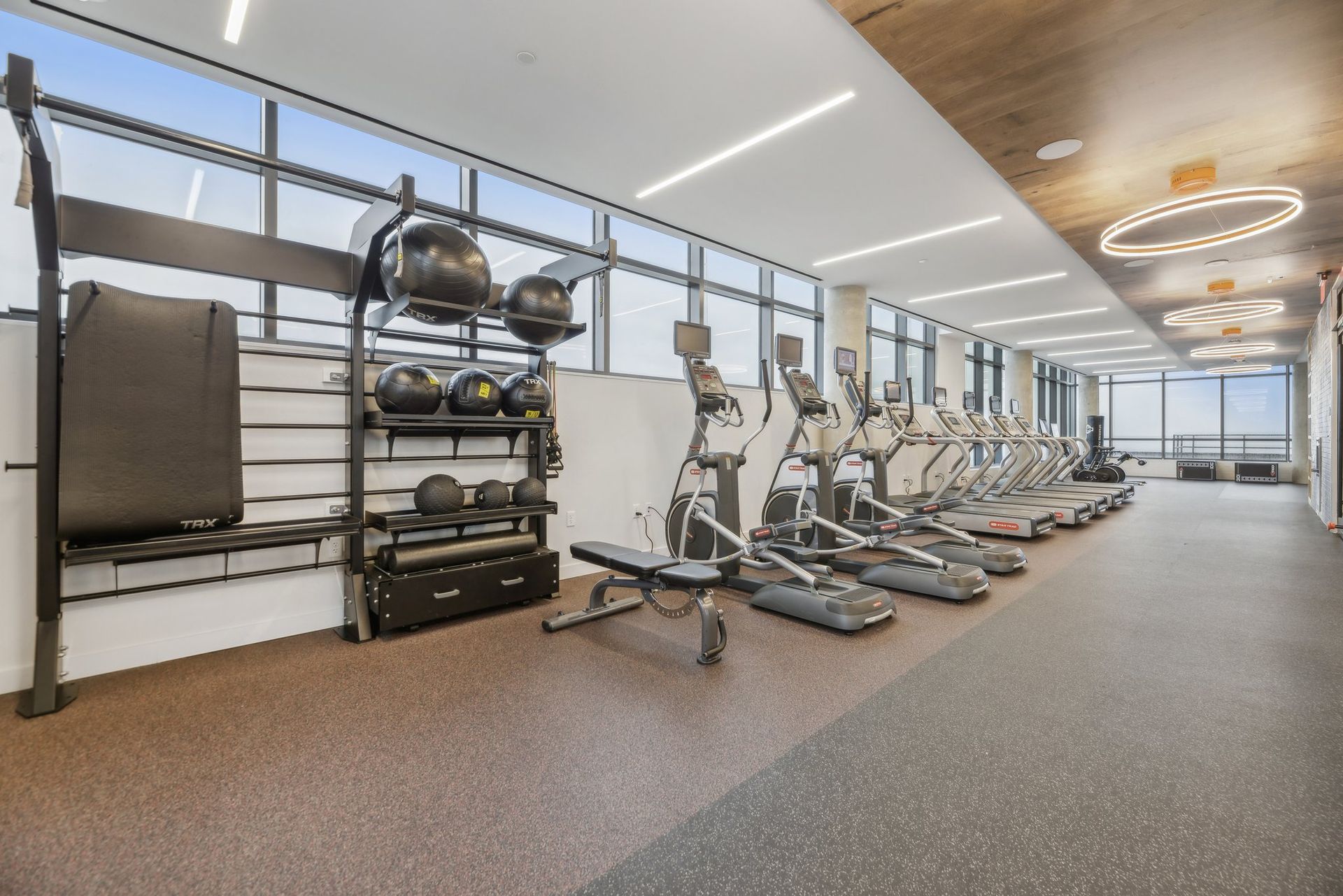 A large gym with a lot of equipment and a lot of windows.