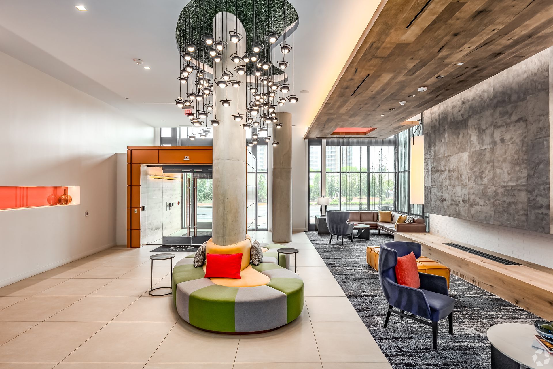 A large lobby with a couch and chairs and a chandelier hanging from the ceiling.