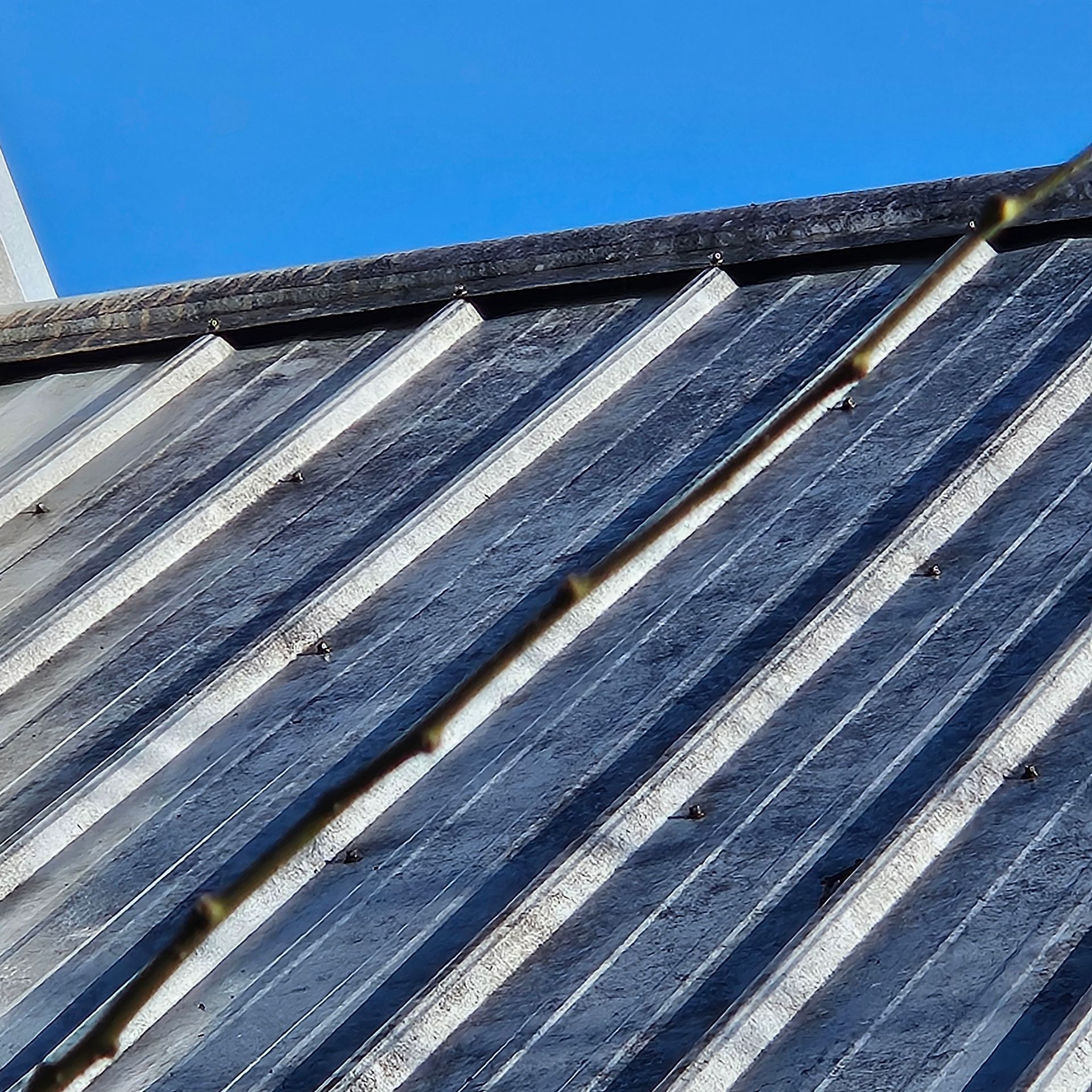 Close-up of a corrugated metal roof with blue sky above