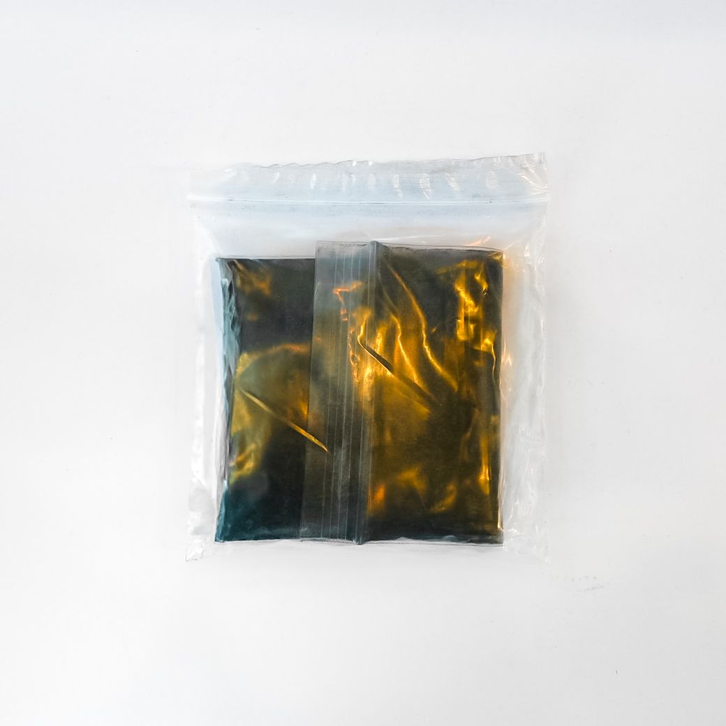 Sealed black packet with a bright yellow label on a white background