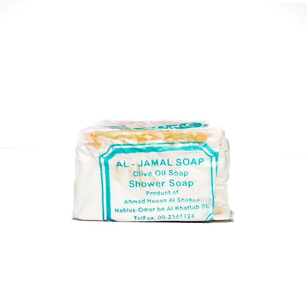 White bar of Al-Jamal soap with teal and orange label on a white background