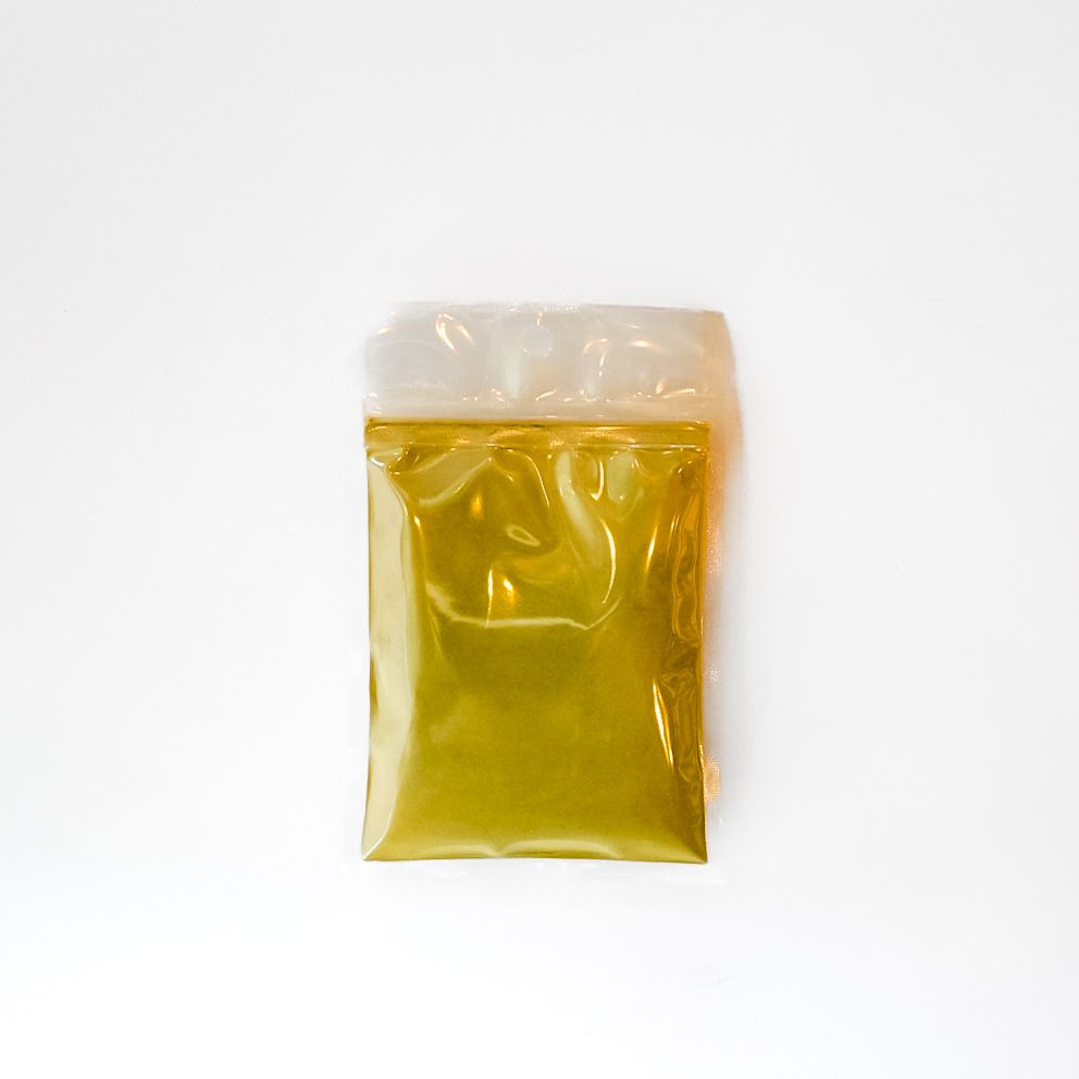 Yellow packaged powder in a clear plastic bag with a bright green label and barcode, isolated on white.