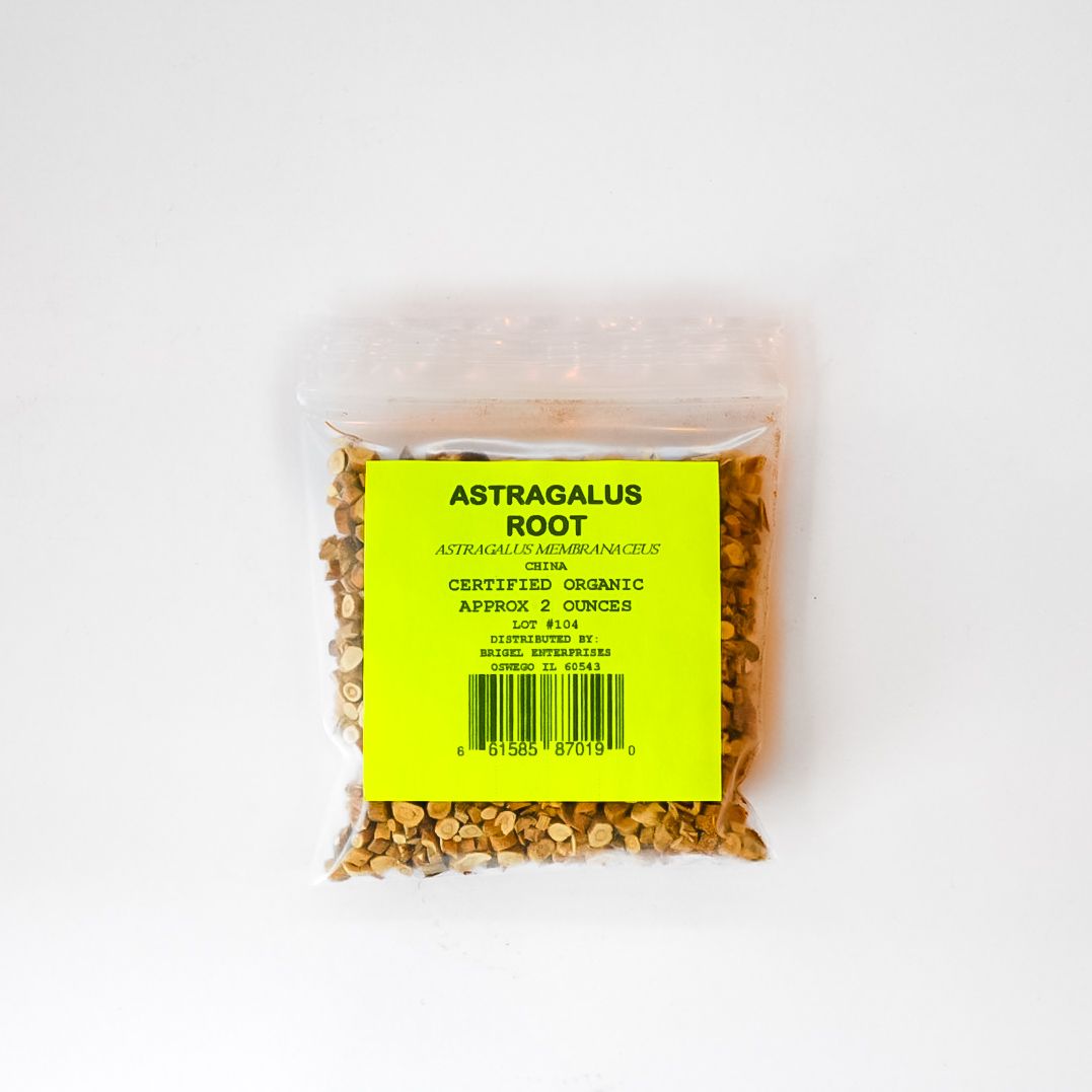 Clear plastic bag of dried astragalus root with a bright yellow label on a white background