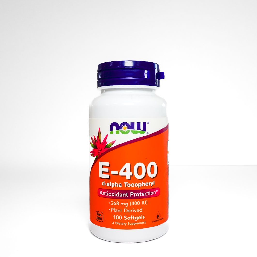 NOW E-400 vitamin E supplement bottle with purple cap and orange label on a white background
