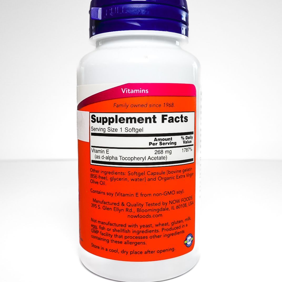 NOW E-400 vitamin E supplement bottle with purple cap and orange label on a white background