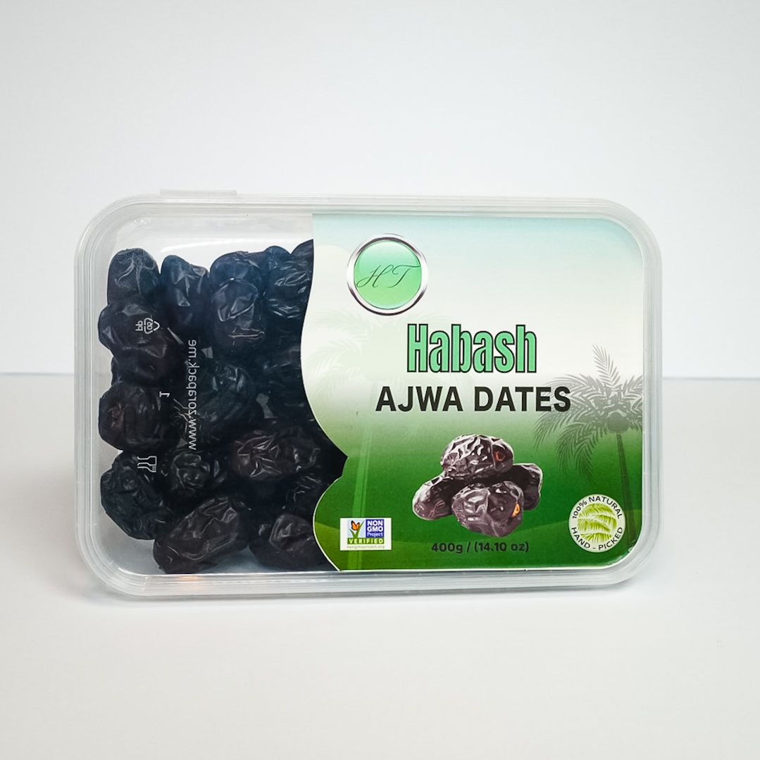 Plastic tub of dark Ajwa dates labeled “Hafash AJWA DATES” on a white background