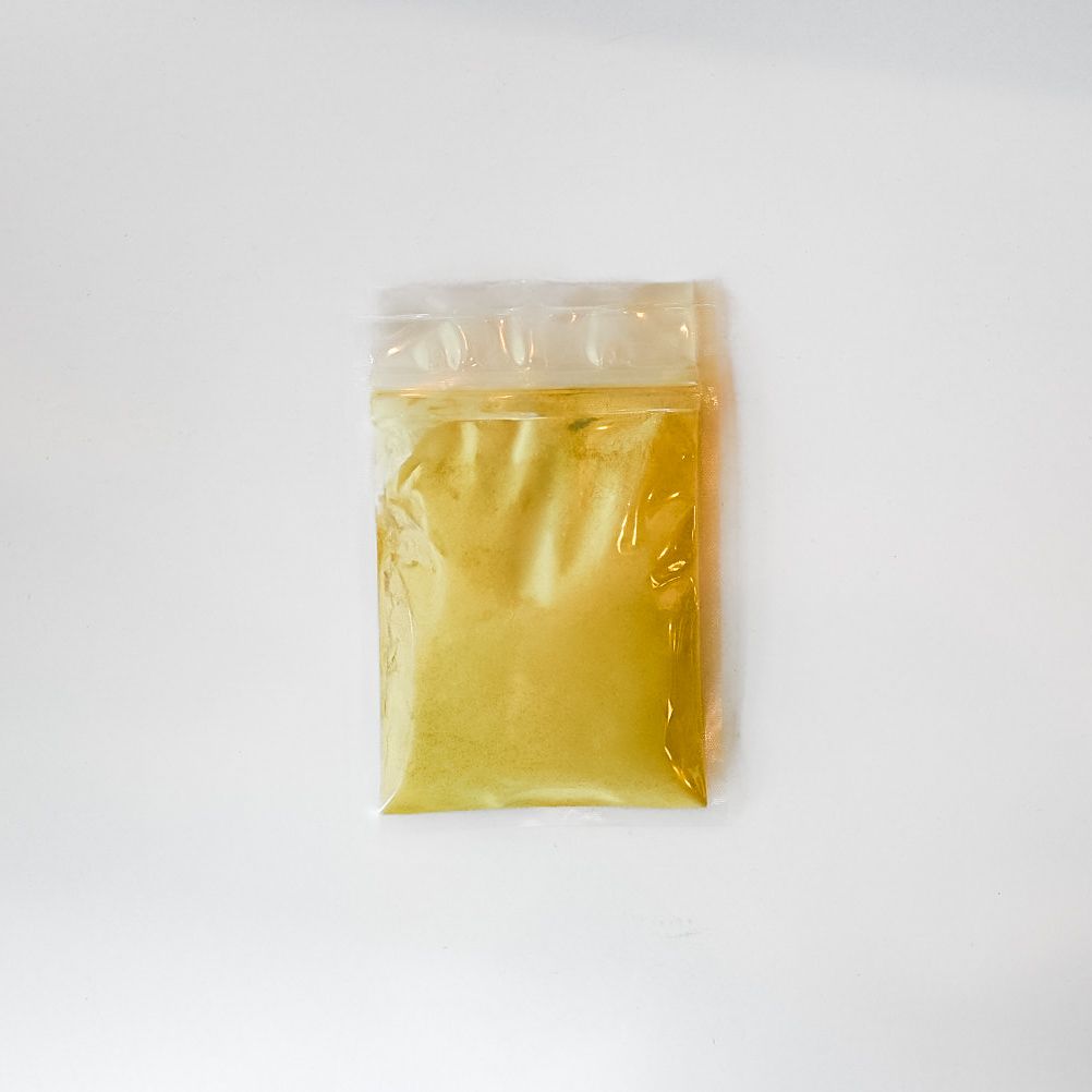Clear plastic bag of black maca powder with a bright yellow label on a white background