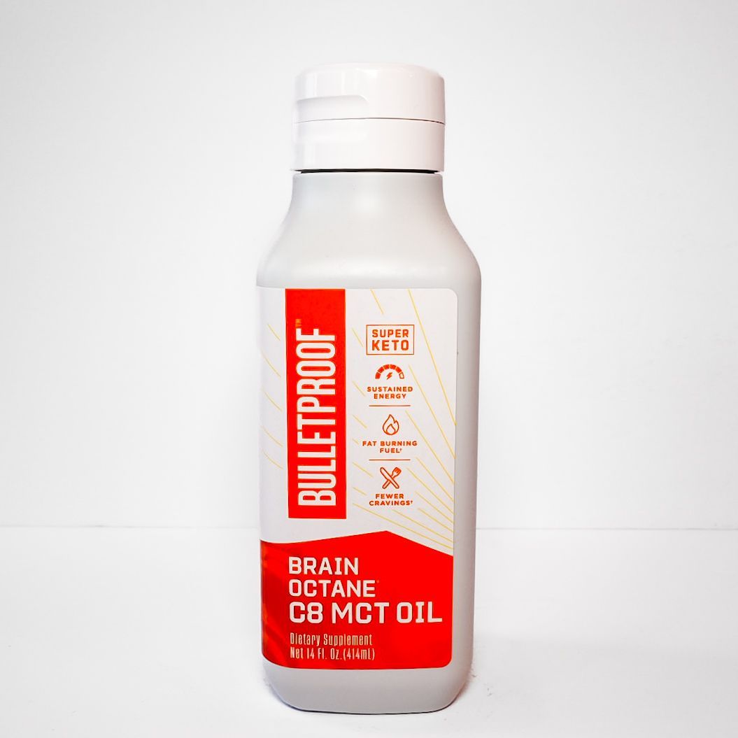 White Bulletproof Brain Octane C8 MCT oil bottle with red label on a light background