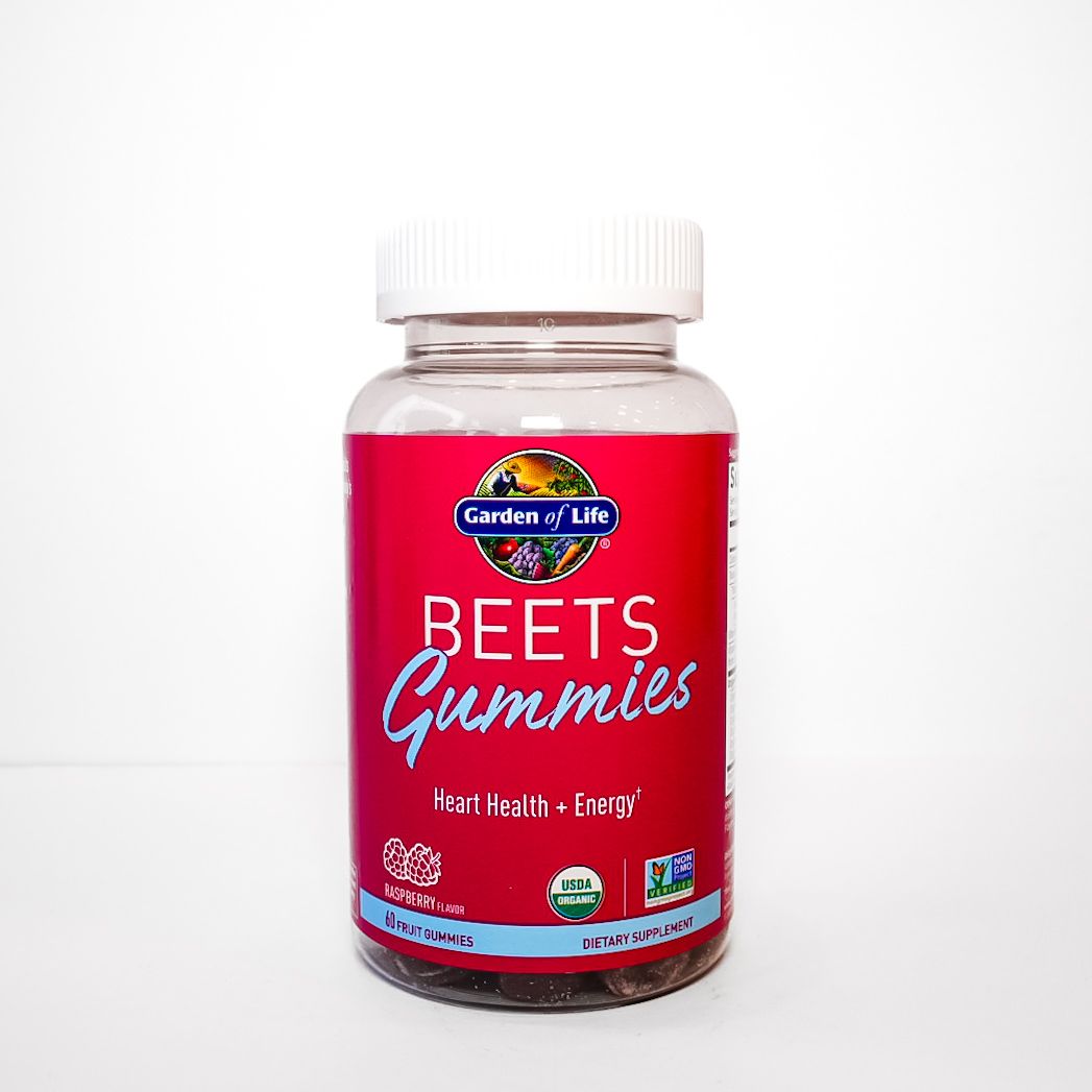 Red bottle of Beets Gummies supplement with white cap on a plain background