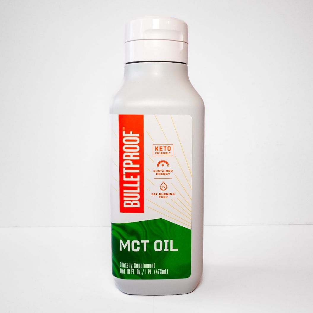 White Bulletproof MCT oil bottle with green label on a plain background