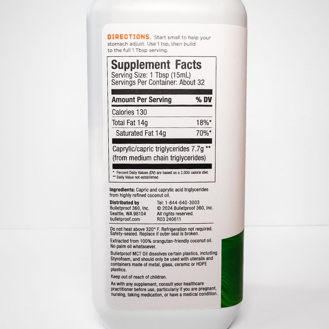 White Bulletproof MCT oil bottle with green label on a plain background