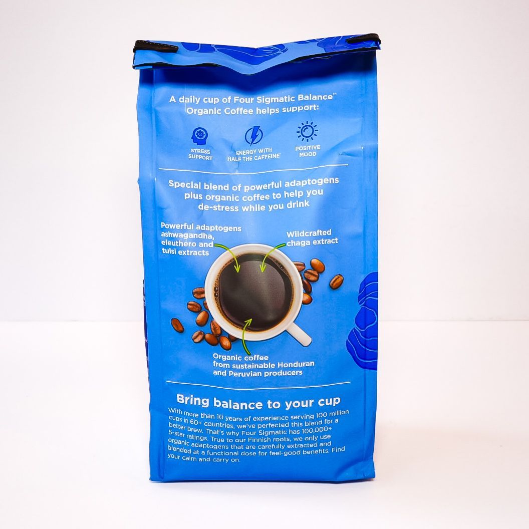 Blue bag of Four Sigmatic Balance organic half coffee with a white label on a plain background