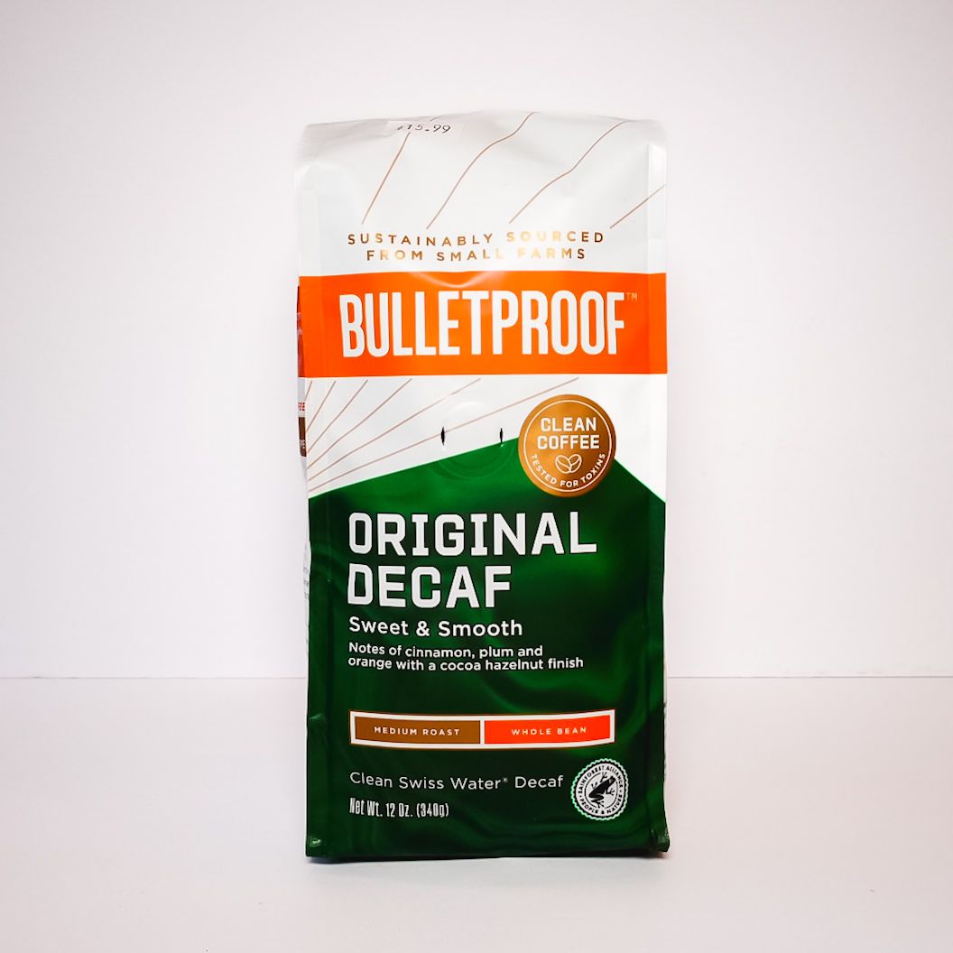 Bulletproof Original Decaf coffee bag, white and green with orange label, standing upright on a plain background