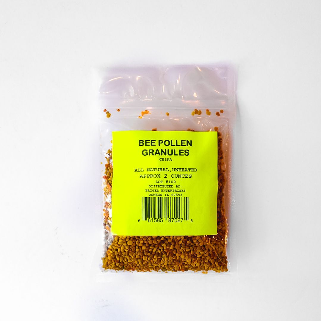 Clear plastic bag of yellow bee pollen granules with a bright green label on a white background