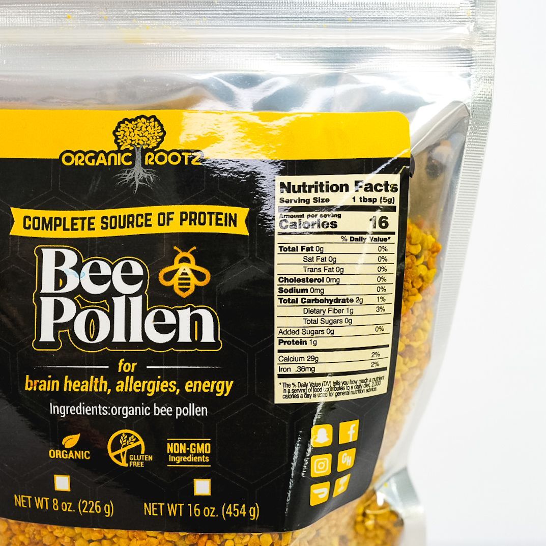 Clear plastic pouch of bee pollen with black and yellow label on a white background