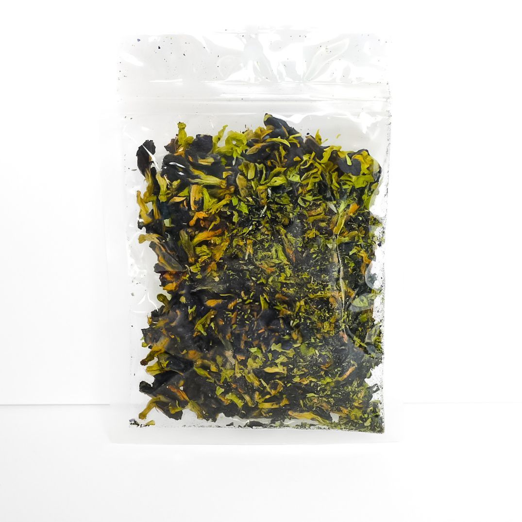 Clear bag of dried butterfly pea flowers with a bright yellow label on a white background