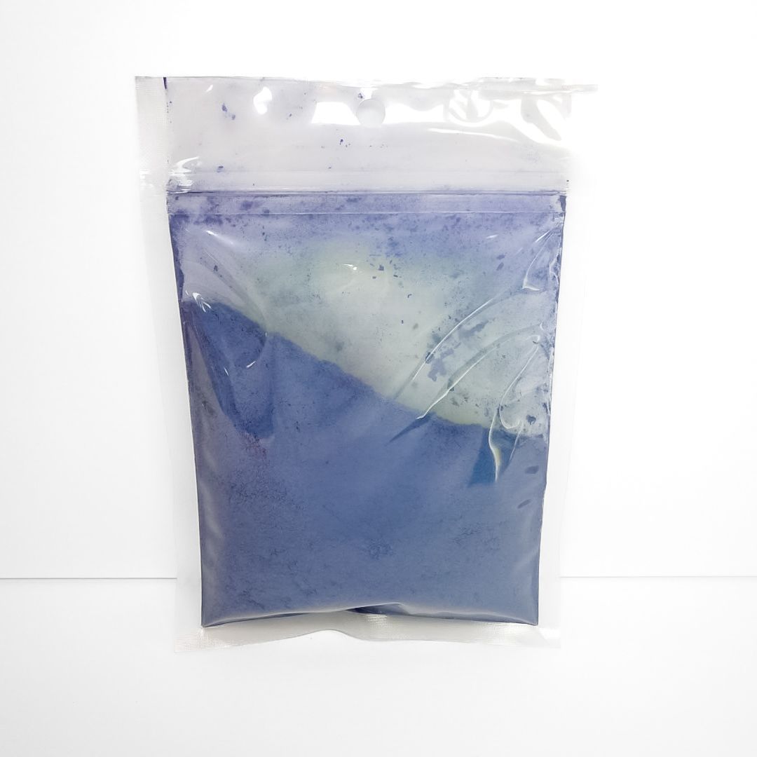 Blue butterfly pea powder in a clear plastic pouch with a yellow label and barcode