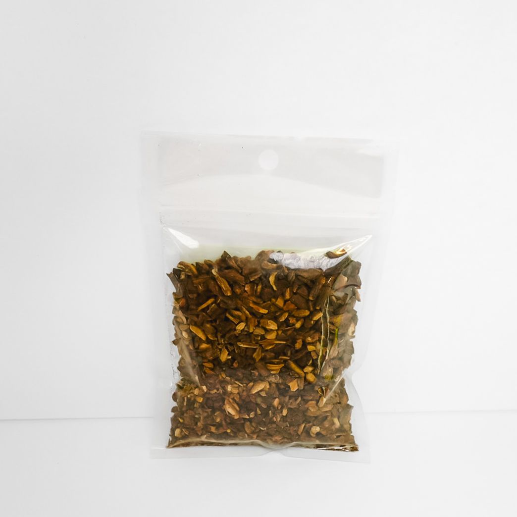 Clear plastic bag of dried roots with a bright yellow label on a white background