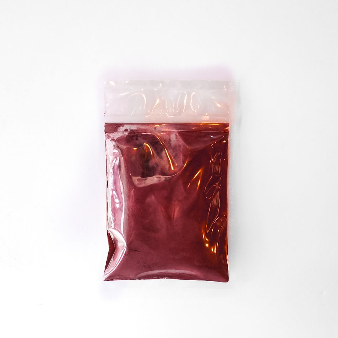 Small clear plastic packet of beet root powder with a bright yellow label on a white background