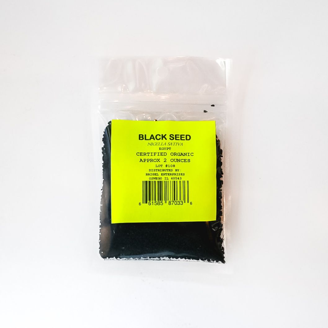 Small clear plastic bag of black seeds with a bright yellow label on a white background