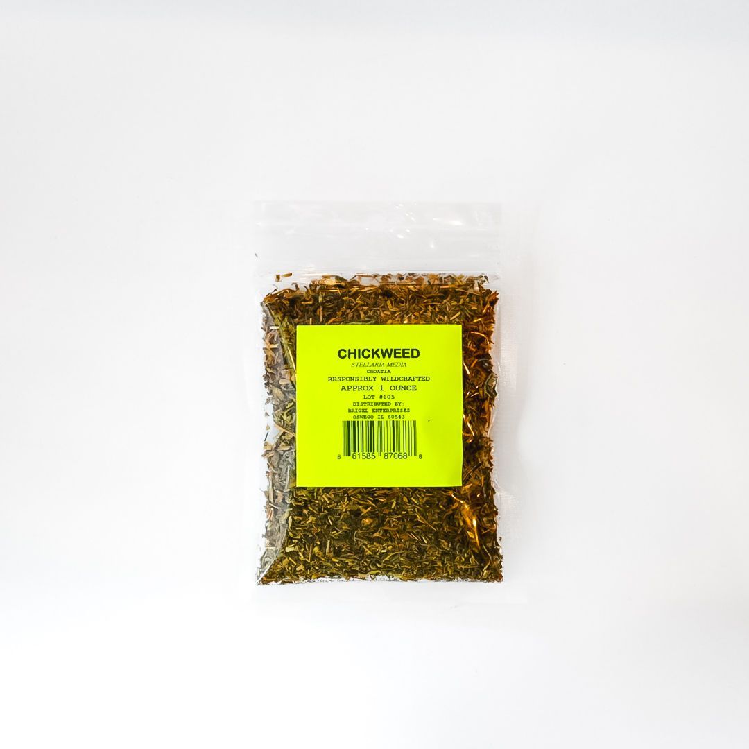Clear plastic bag of dried herbs or tea with a bright yellow label on a white background