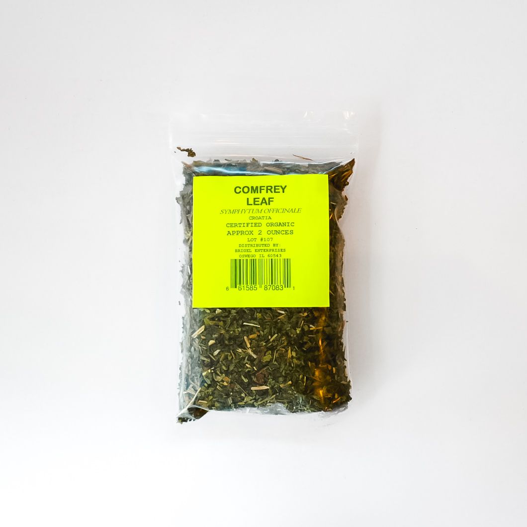 Clear bag of loose tea leaves with a bright yellow label on a white background