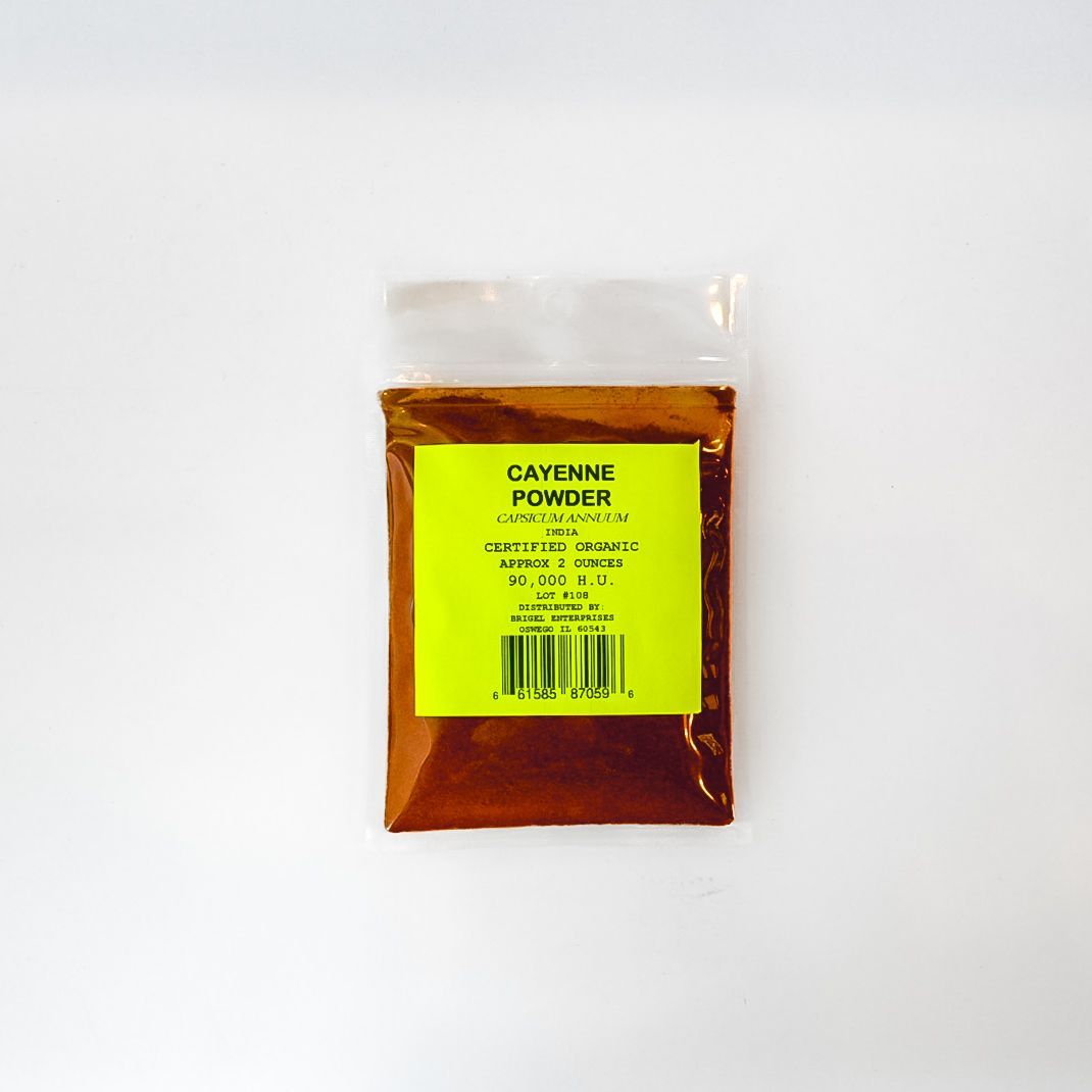 Small clear plastic bag of cayenne pepper with a bright green label on a white background