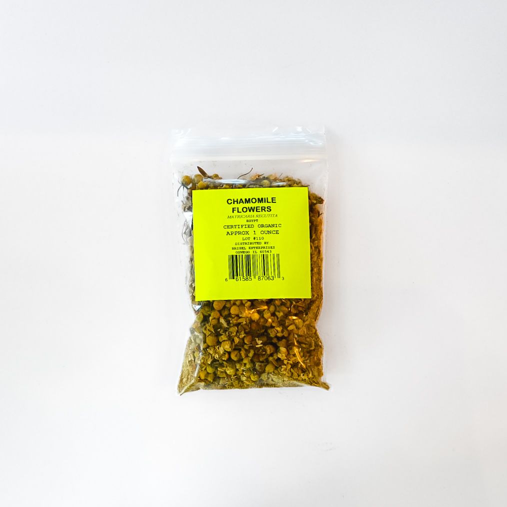 Clear bag of chamomile flowers with bright yellow label on a white background