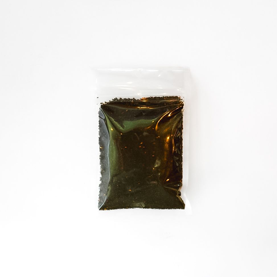 Small clear bag of roasted chicory root powder with a bright yellow label on a white background