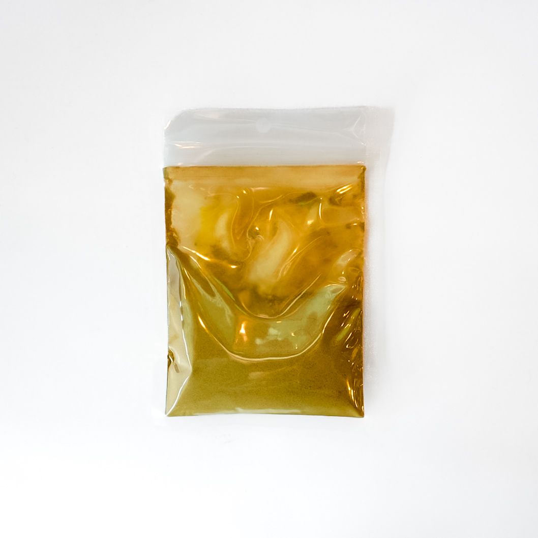 Small clear plastic bag of yellow liquid with a bright green label on a white background