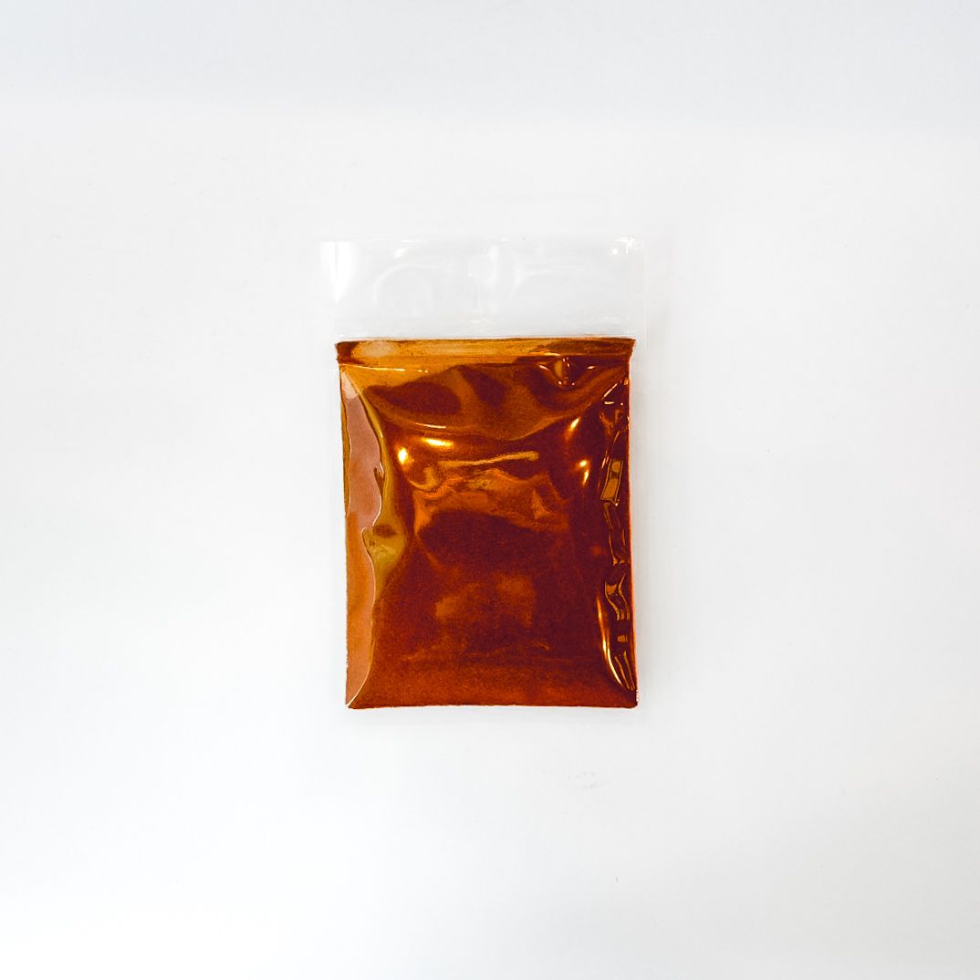 Small clear plastic bag of cayenne pepper with a bright green label on a white background