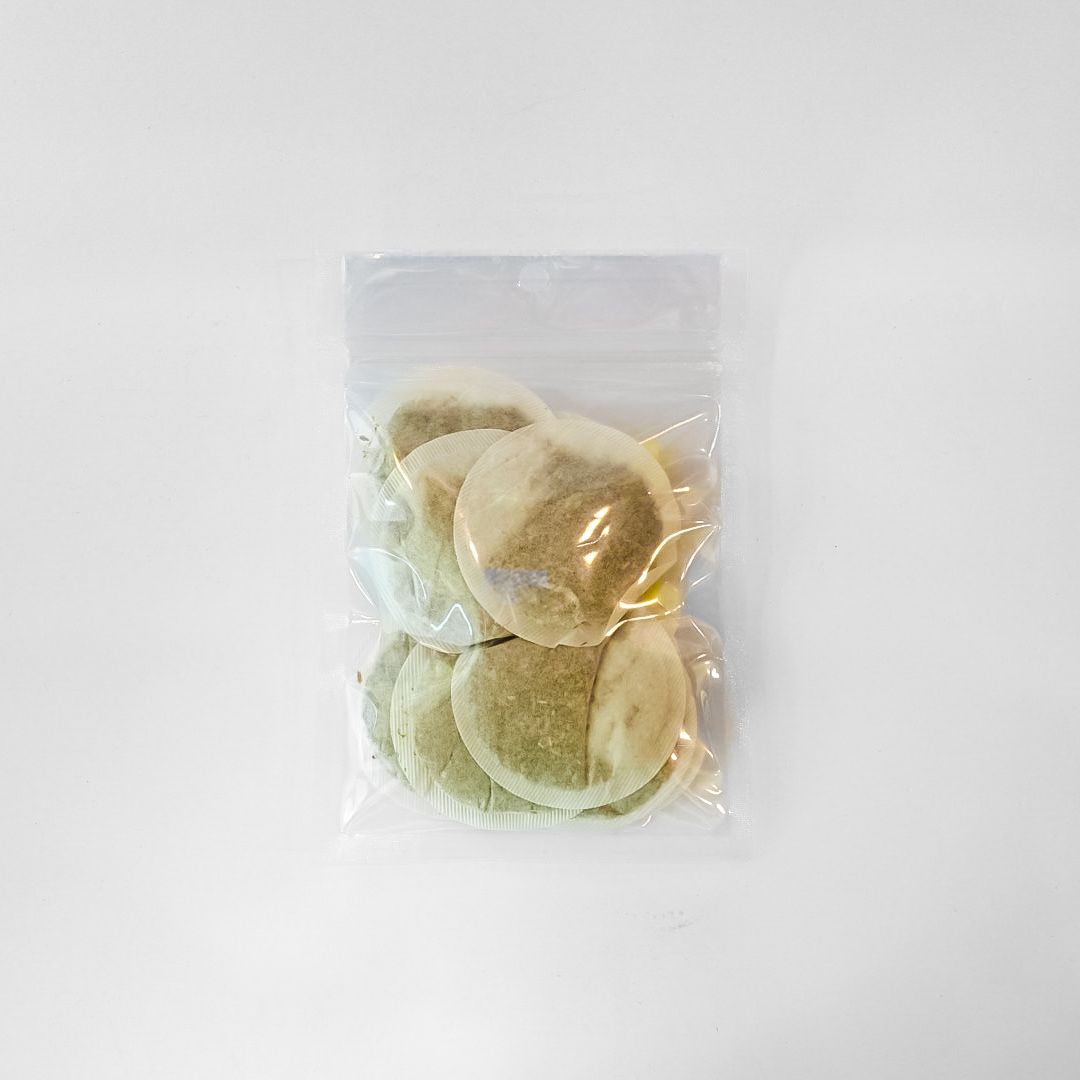 Clear plastic bag of chamomile tea bags with a bright yellow label on a white background