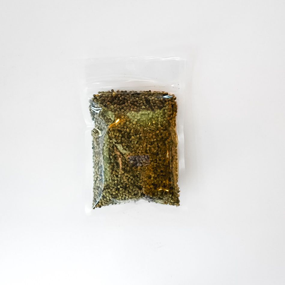 Small clear plastic bag of dried herbs with a bright yellow label on a white background