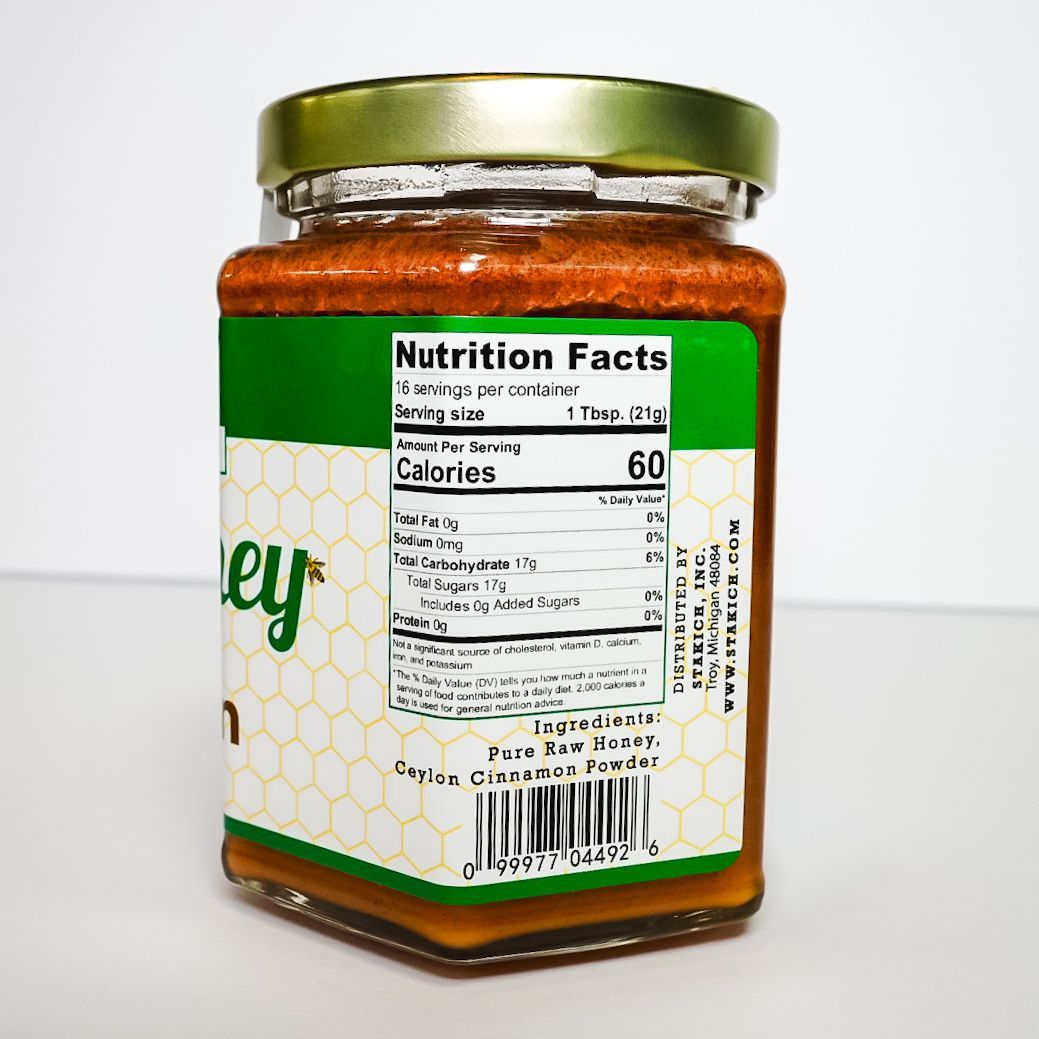 Jar of honey with green lid and nutrition label, shown on a white background