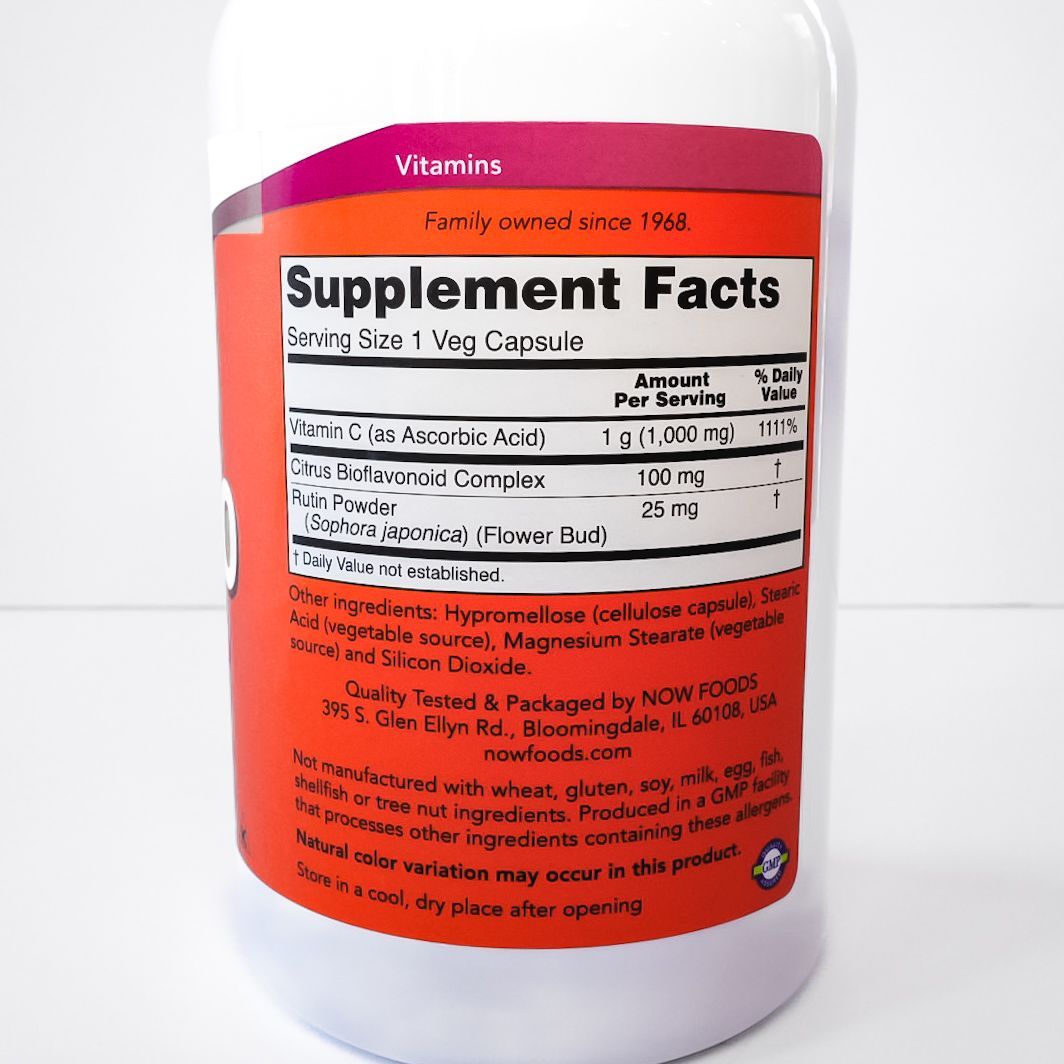 White vitamin supplement bottle with orange label showing Supplement Facts panel