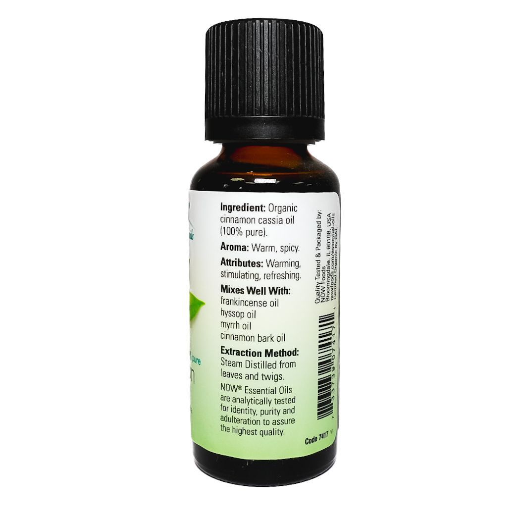 Small brown bottle of NOW cinnamon cassia essential oil with a green leaf label on a white background