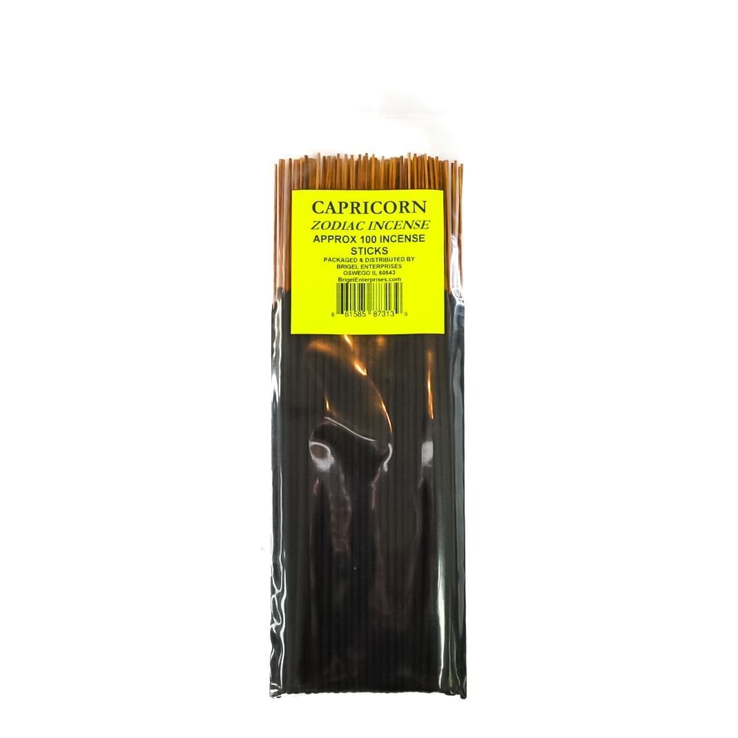 Black packaged item with a yellow label and brown sticks at the top, isolated on white background